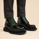 Green-black polished lace-up boots on-foot studio photo